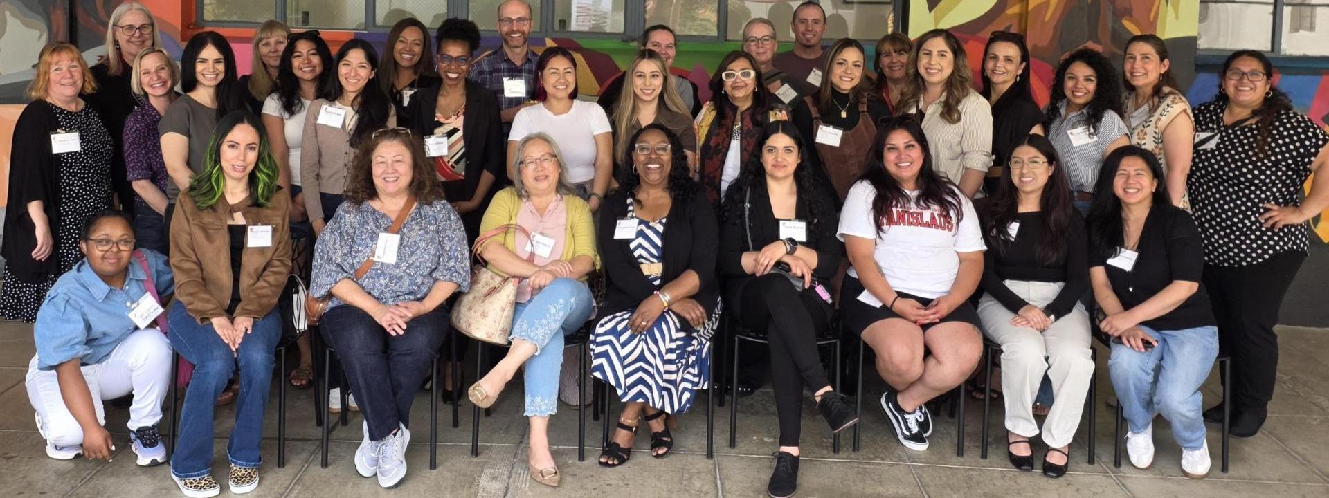 A group photo of MSW Hybrid staff members in front of a Stockton campus building.