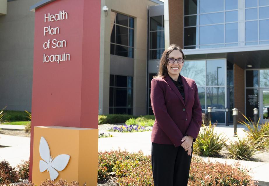 Female standing in front of "Health Plan of San Joaquin" sign