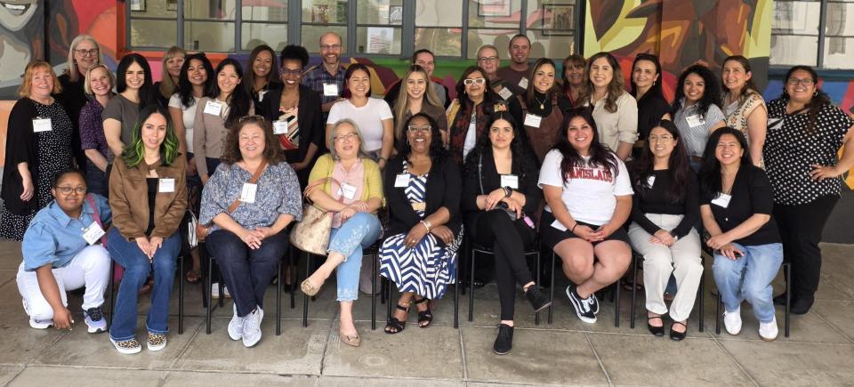 A group photo of MSW Hybrid staff members in front of a Stockton campus building.