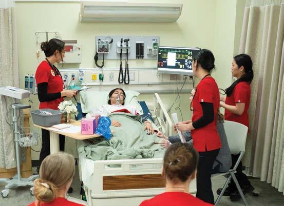 Nursing students looking over an actress patient.