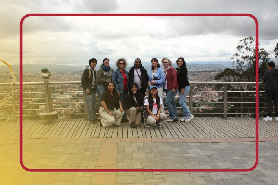 Group of students posing for a photo with an open sky behind them