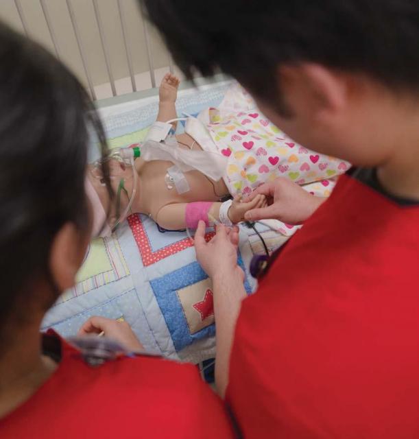 Nursing students overlooking a prop baby